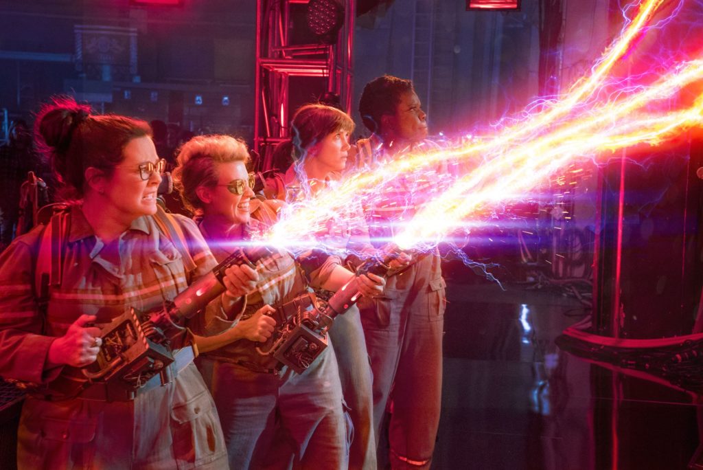 A scene from the 2016 film showing four members of the Ghostbusters attempting to close a dangerous portal by crossing the streams from their proton packs.