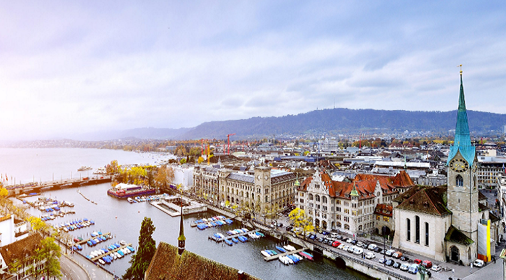 Historic buildings sit on both sides of the Limmat River where it empties into Lake Zurich.