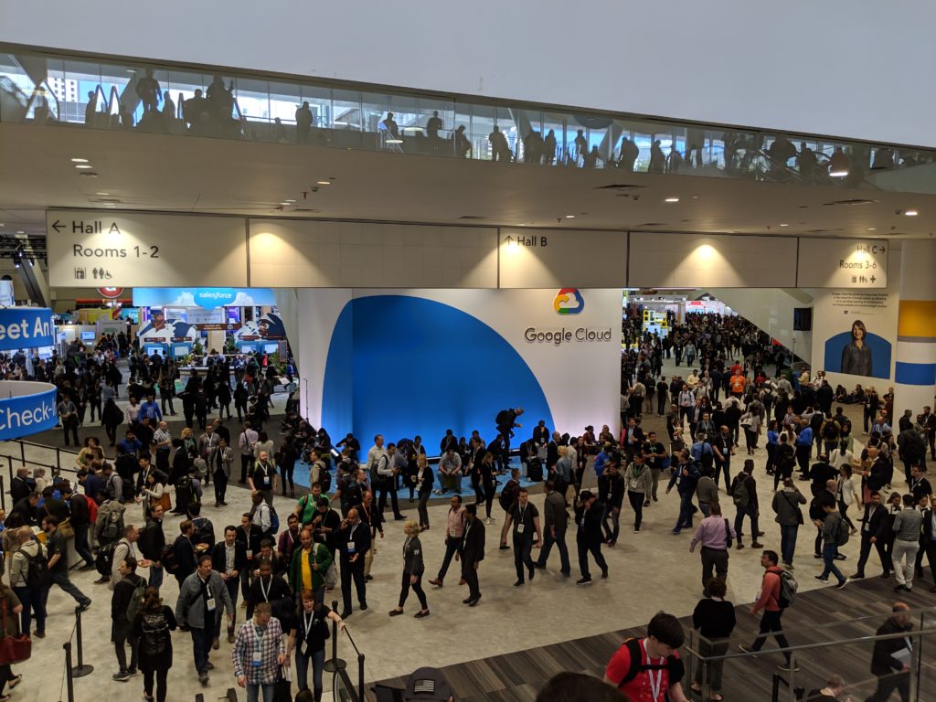 Many people walking in front of a display for Google Cloud at the entrance to the Google Next 2019 expo hall