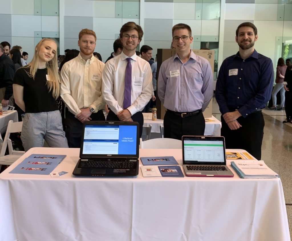 Team 8332 showcases the online evaluation tool they developed for their client, Jacob’s Ladder Neurodevelopmental School and Therapy Center. Their table includes two laptops demonstrating the software and handouts describing how the app works.