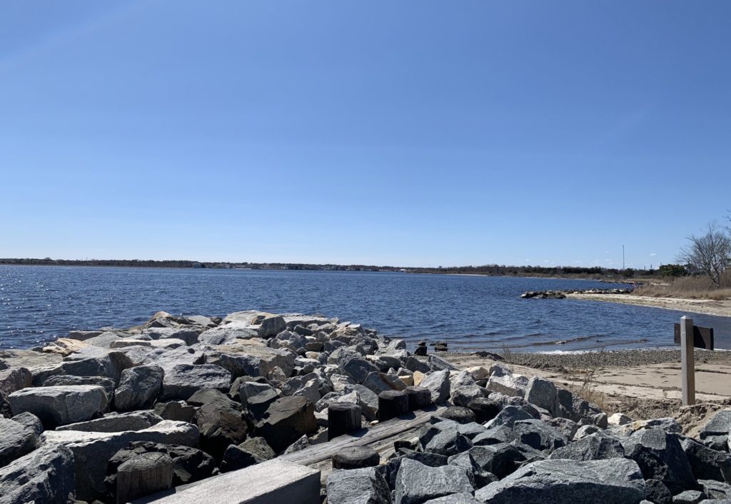 View of Barnegat Bay (NJ) with rock jetty and sand in the foreground