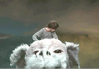 Gif from The Neverending Story of Bastian (a boy) flying through the air on the back of Falkor (a dragon) and exclaiming "yes!"