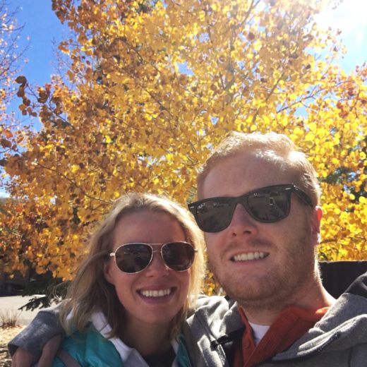 Rachel and Devin in front of fall foliage.