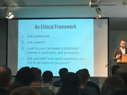 Kevin Barrett on stage with a slide showing an ethical framework.