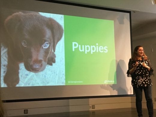 Claire Giordano on stage with a slide showing a puppy.