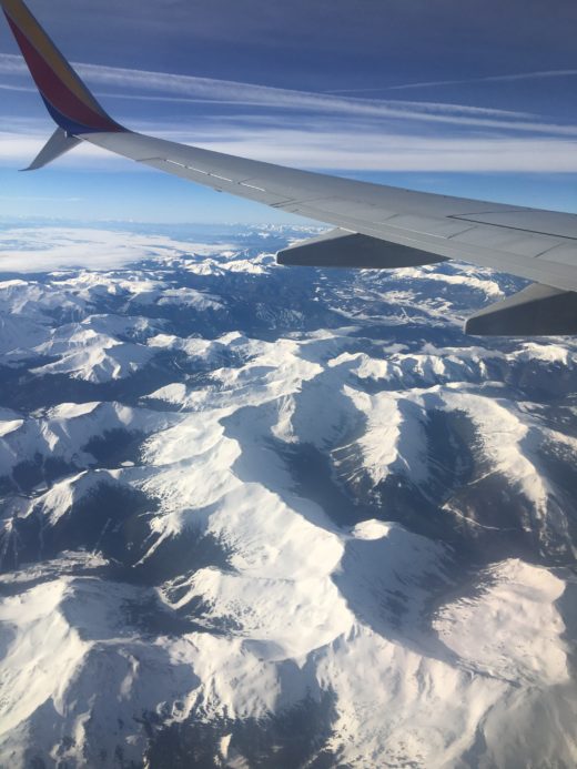 in-flight photo of airplane wing overlooking mountains